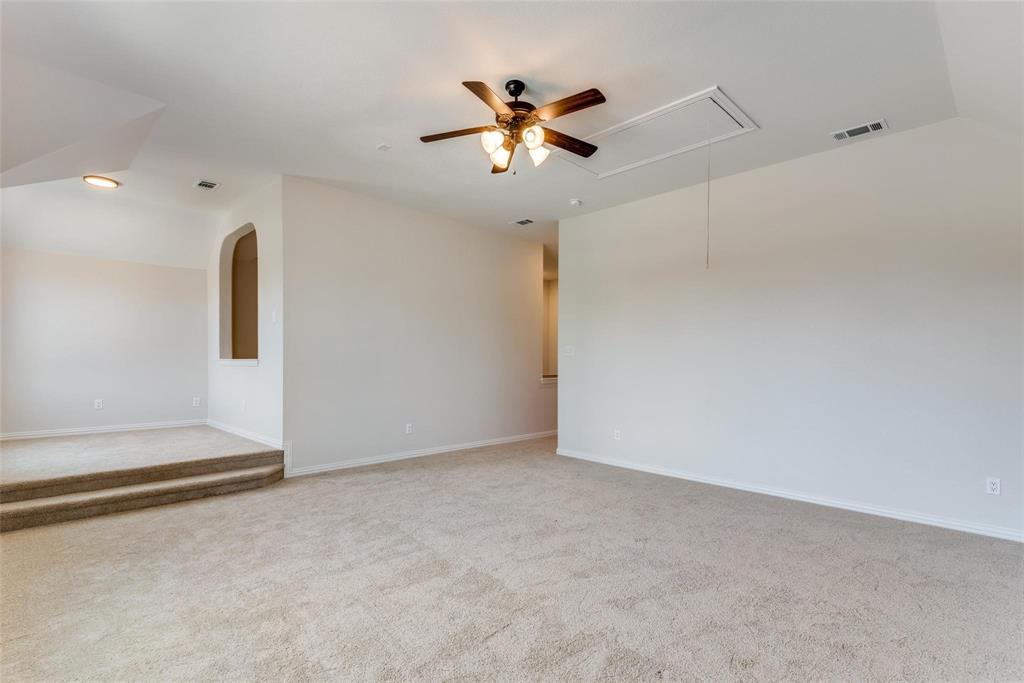 2344 Ranchview Drive Little Elm, TX 75068 - Photo 15 of 24 Expansive carpeted room featuring a ceiling fan with integrated lighting, vaulted ceilings, and a raised platform area