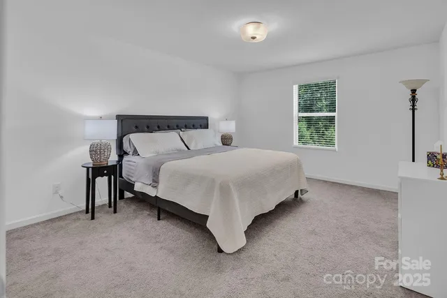 a large bed sitting in a bedroom next to a window and a larger closet