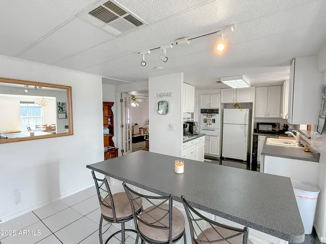 a kitchen with kitchen island granite countertop a sink cabinets and stainless steel appliances