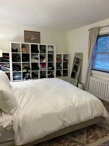 a large bed sitting in a bedroom next to a window with furniture