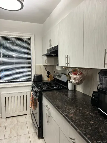 a kitchen with a stove a sink and cabinets