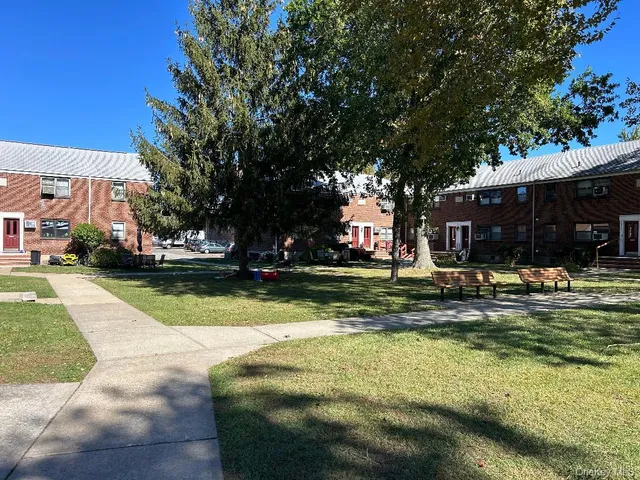 a view of swimming pool with outdoor seating and house in the background