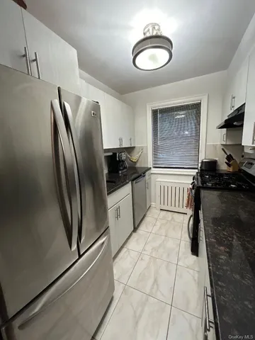 a kitchen with stainless steel appliances granite countertop a refrigerator and a stove top oven