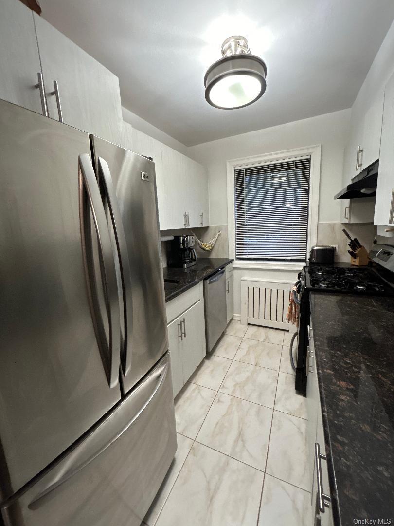 199-08 21st Avenue, Unit 1327 Queens, NY 11357 - Photo 3 of 21 a kitchen with stainless steel appliances granite countertop a refrigerator and a stove top oven