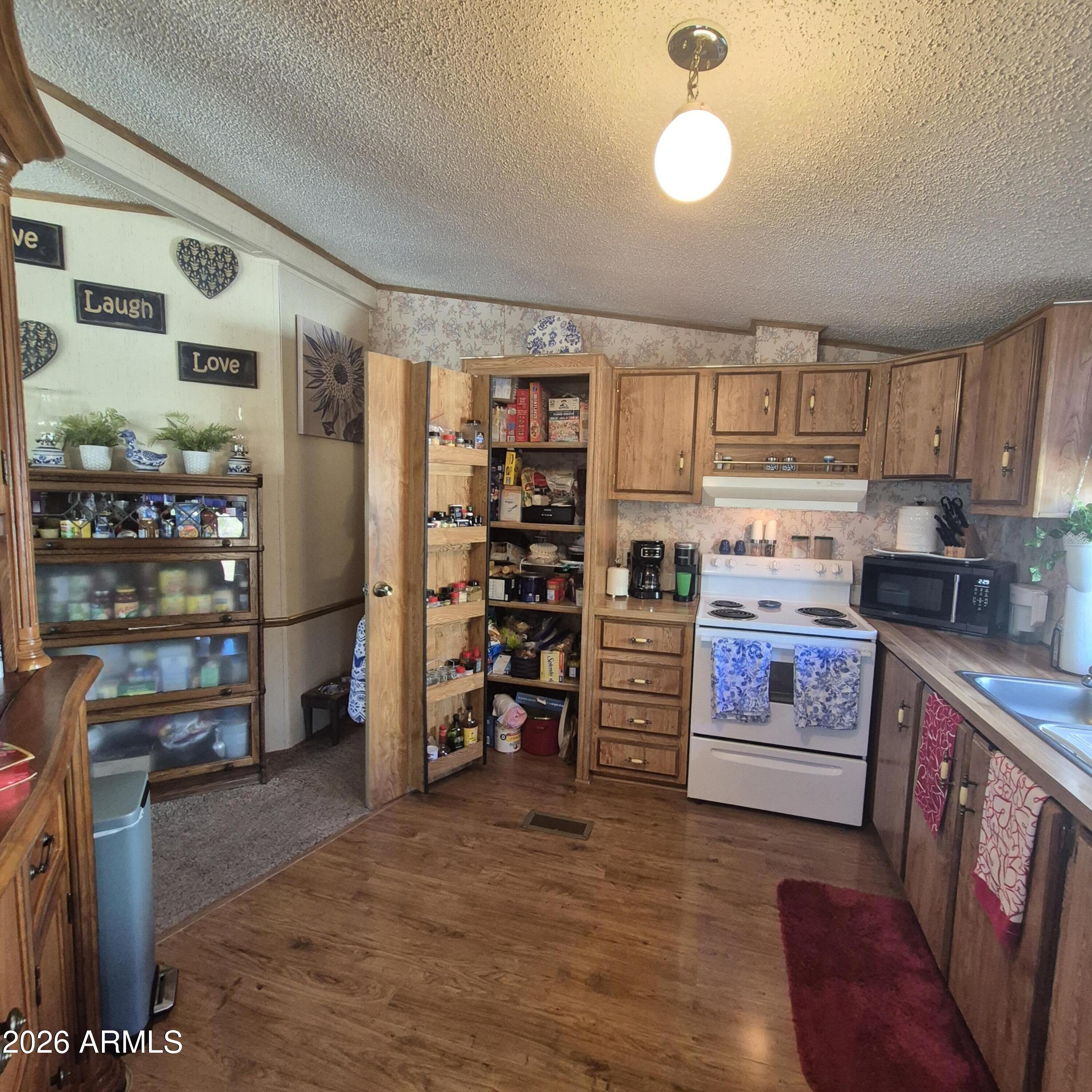1980 South Hilton Road Apache Junction, AZ 85119 - Photo 15 of 42 a kitchen with stainless steel appliances a stove top oven and a refrigerator