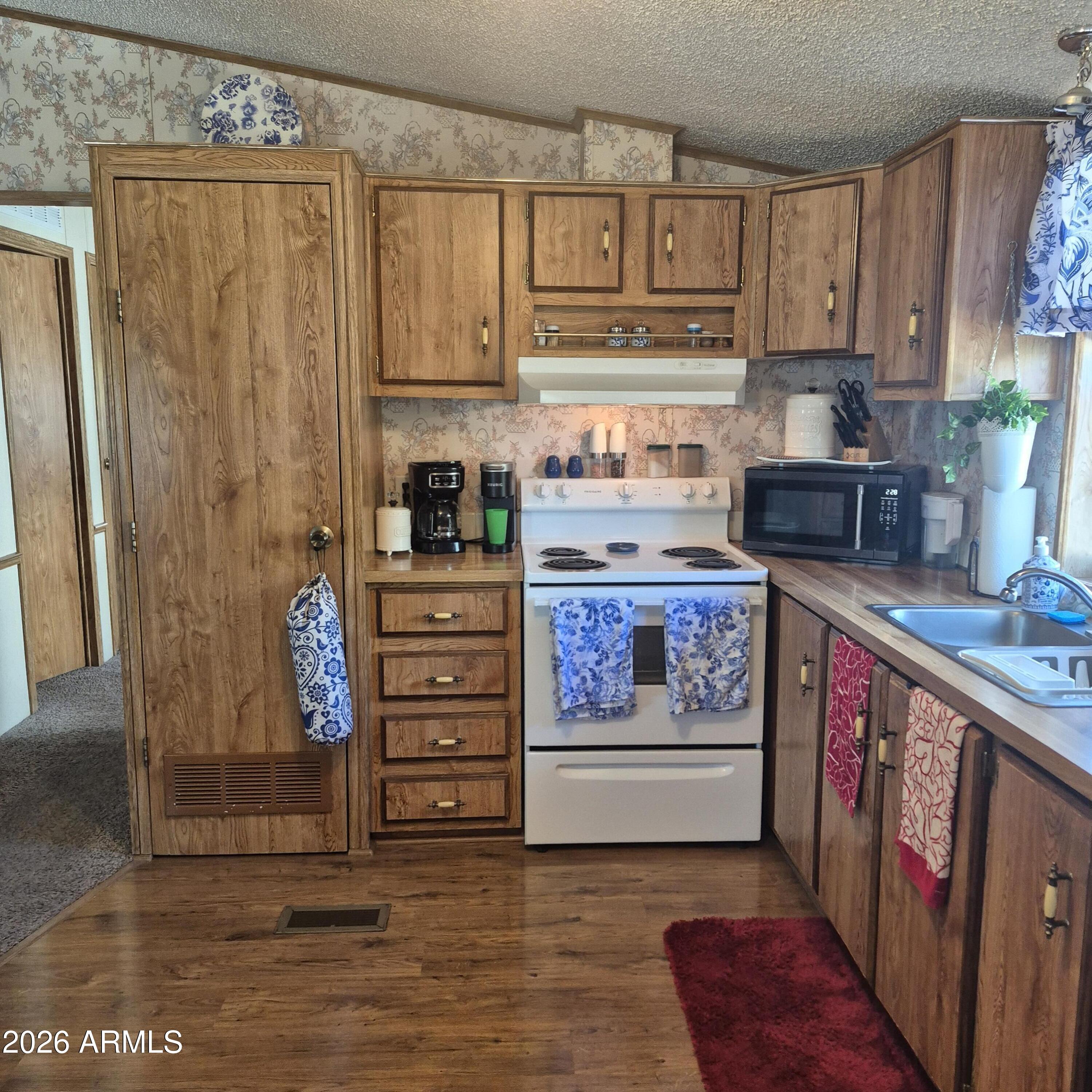 1980 South Hilton Road Apache Junction, AZ 85119 - Photo 9 of 42 a kitchen with stainless steel appliances granite countertop a refrigerator and a stove top oven