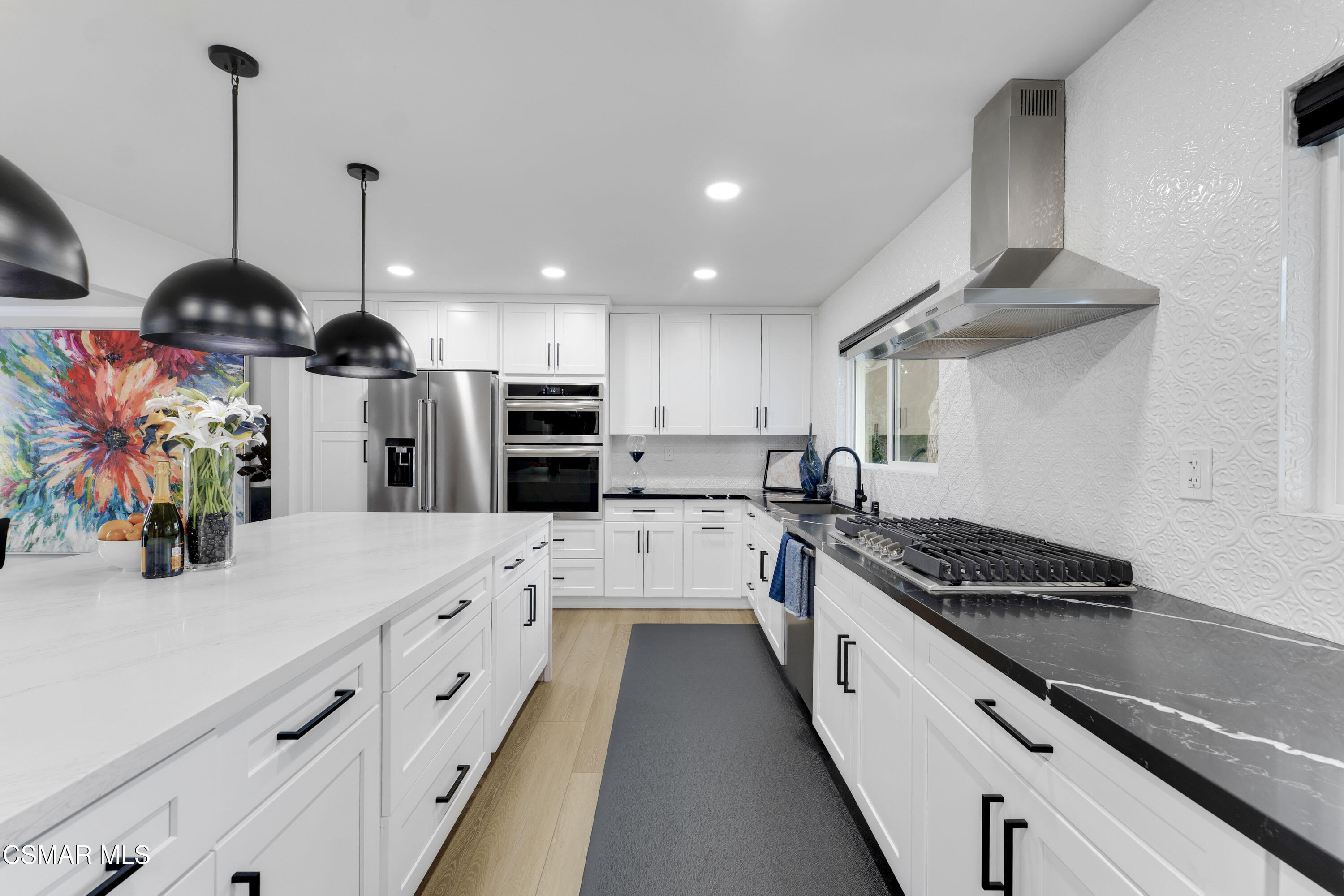 19120 Salt Lake Place Porter Ranch, CA 91326 - Photo 11 of 47 a kitchen with stainless steel appliances kitchen island granite countertop a sink a stove and a wooden floors