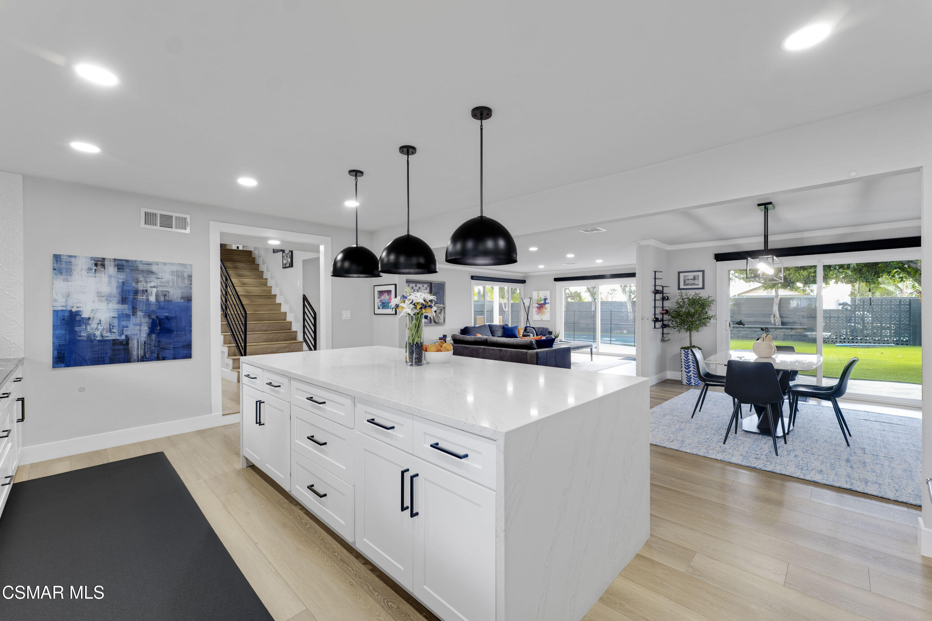 19120 Salt Lake Place Porter Ranch, CA 91326 - Photo 14 of 47 a large kitchen with kitchen island stainless steel appliances a table chairs and a chandelier