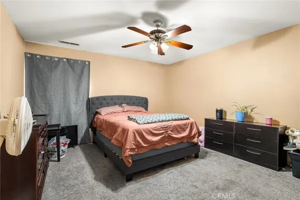 a spacious bedroom with a bed and a chandelier