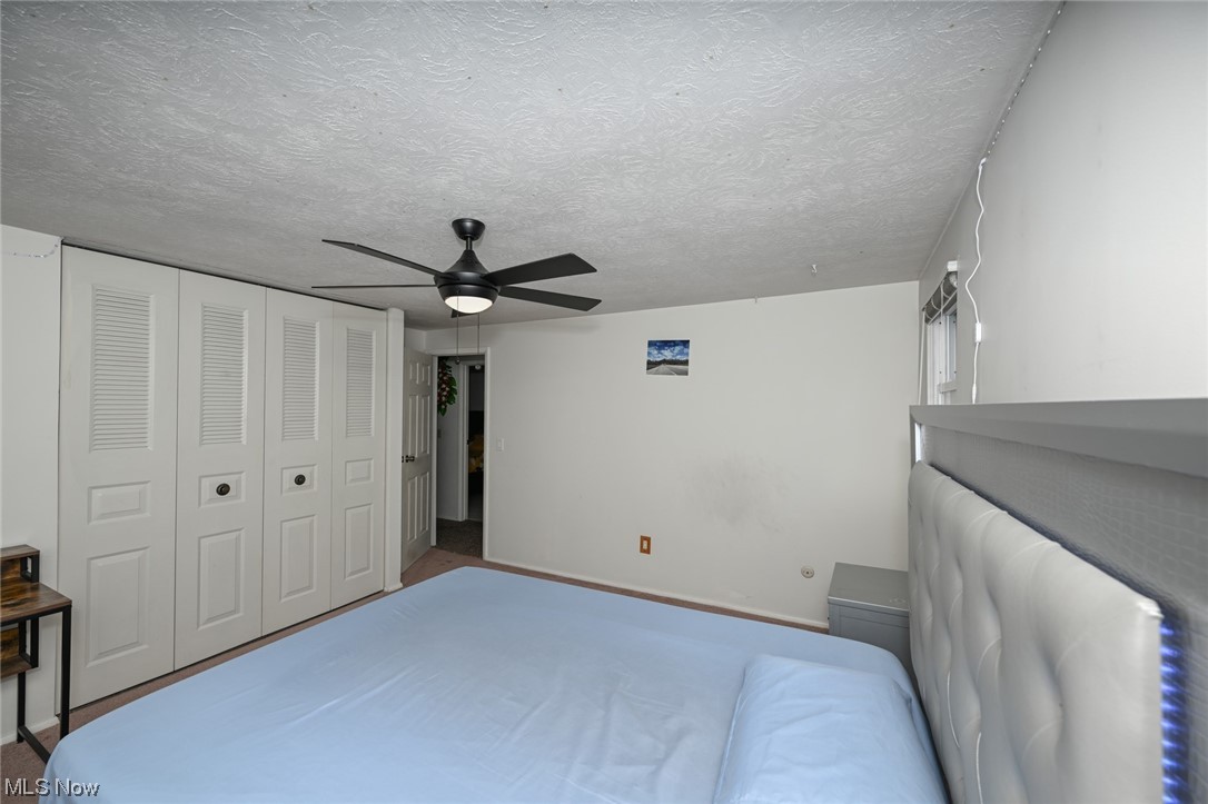 4574 Fishcreek Road Stow, OH 44224 - Photo 40 of 49 Bedroom featuring carpet, a closet, a textured ceiling, and ceiling fan