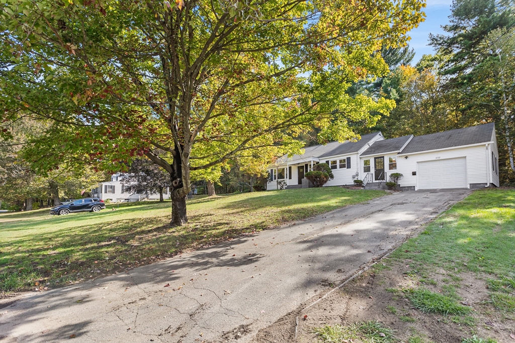 222 Forge Village Road Groton, MA 01450 - Photo 2 of 12 a front view of house with yard and green space