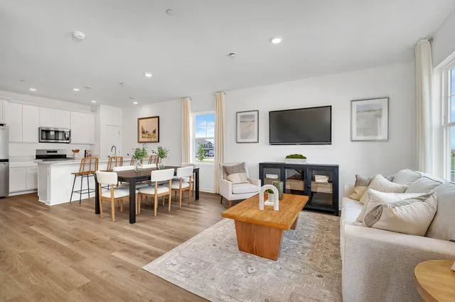 a living room with furniture a flat screen tv and kitchen view