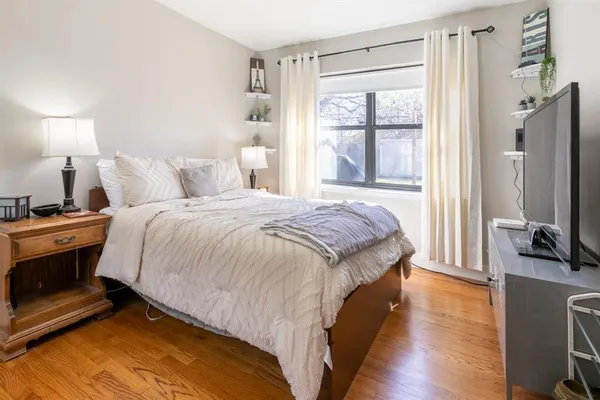 a bedroom with a bed and a flat tv screen on a dresser