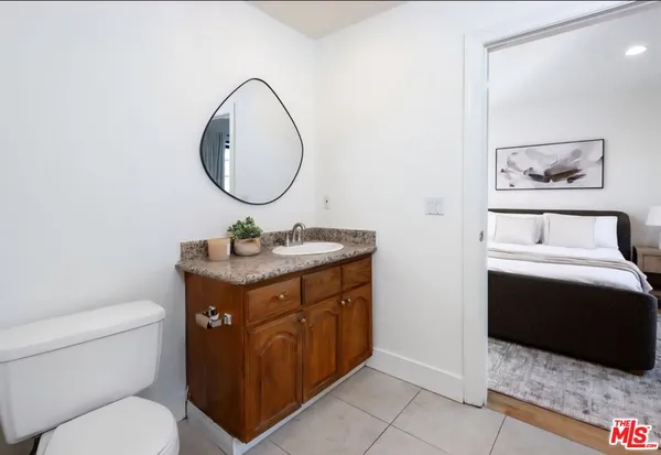 a bathroom with a granite countertop toilet a mirror and a sink
