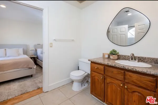 a bathroom with a granite countertop toilet sink and a mirror