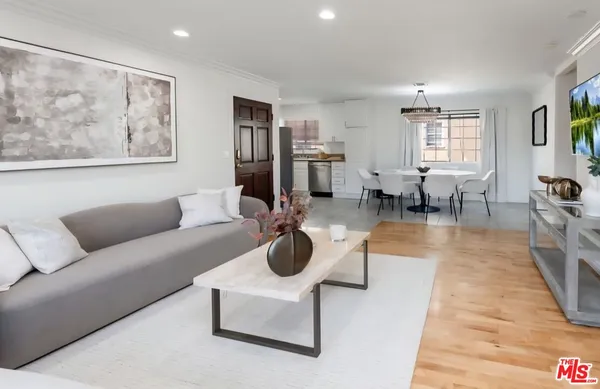 a living room with furniture large window and wooden floor