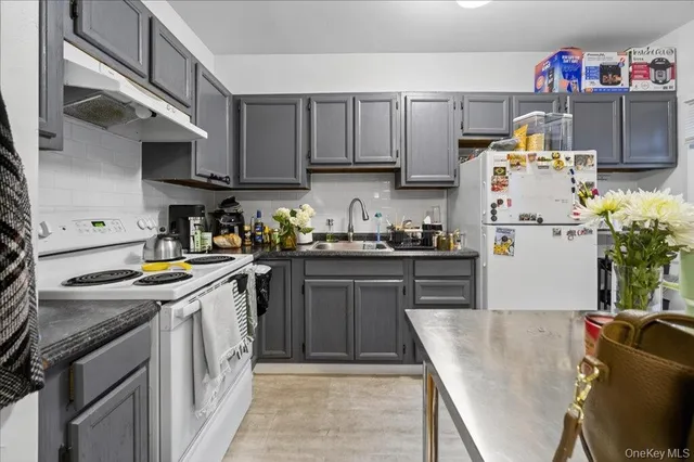 a kitchen with stainless steel appliances granite countertop a refrigerator a stove top oven a sink and dishwasher