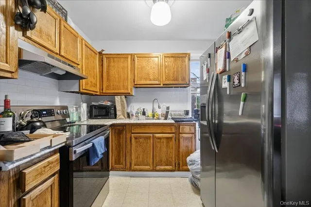 a kitchen with stainless steel appliances granite countertop a sink a stove and a refrigerator