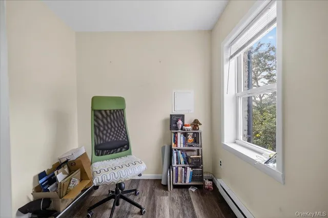 a view of a workspace with furniture and a window