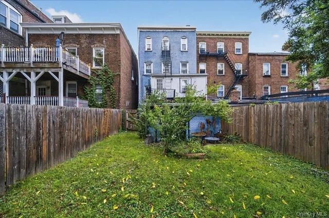 a view of a house with a small yard and wooden fence