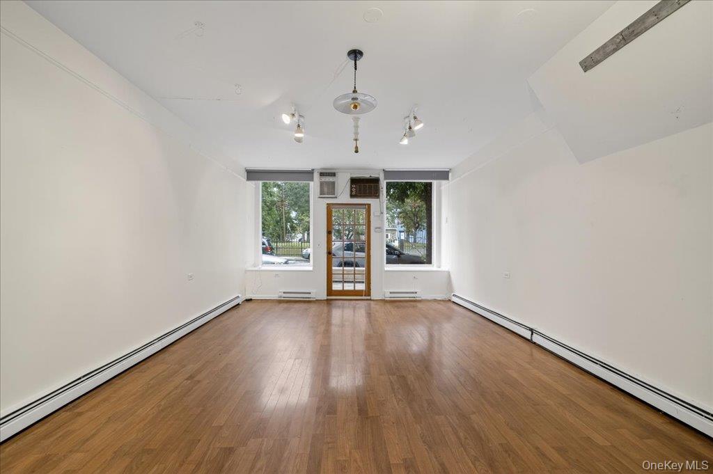 89 Liberty Street Newburgh, NY 12550 - Photo 4 of 33 an empty room with wooden floor chandelier and windows