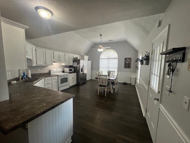 2938 Simmons Road Drummonds, TN 38023 - Photo 3 of 13 Kitchen featuring stainless steel appliances, dark countertops, lofted ceiling, a textured ceiling, and dark wood-style floors