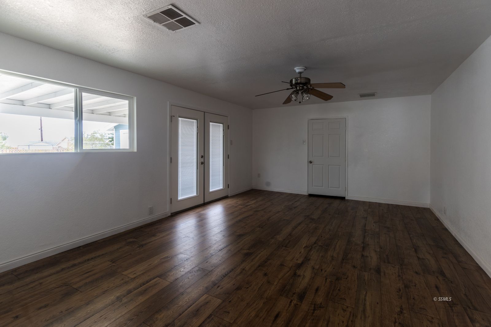 927 West Sullivan Avenue Ridgecrest, CA 93555 - Photo 13 of 24 an empty room with wooden floor and windows