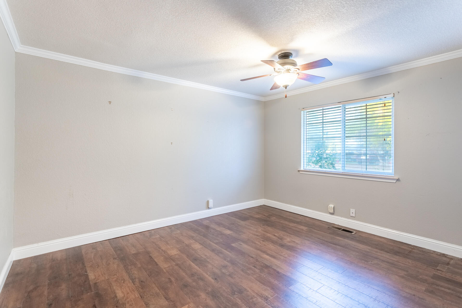 6766 Drake Drive Anderson, CA 96007 - Photo 39 of 44 an empty room with wooden floor fan and windows