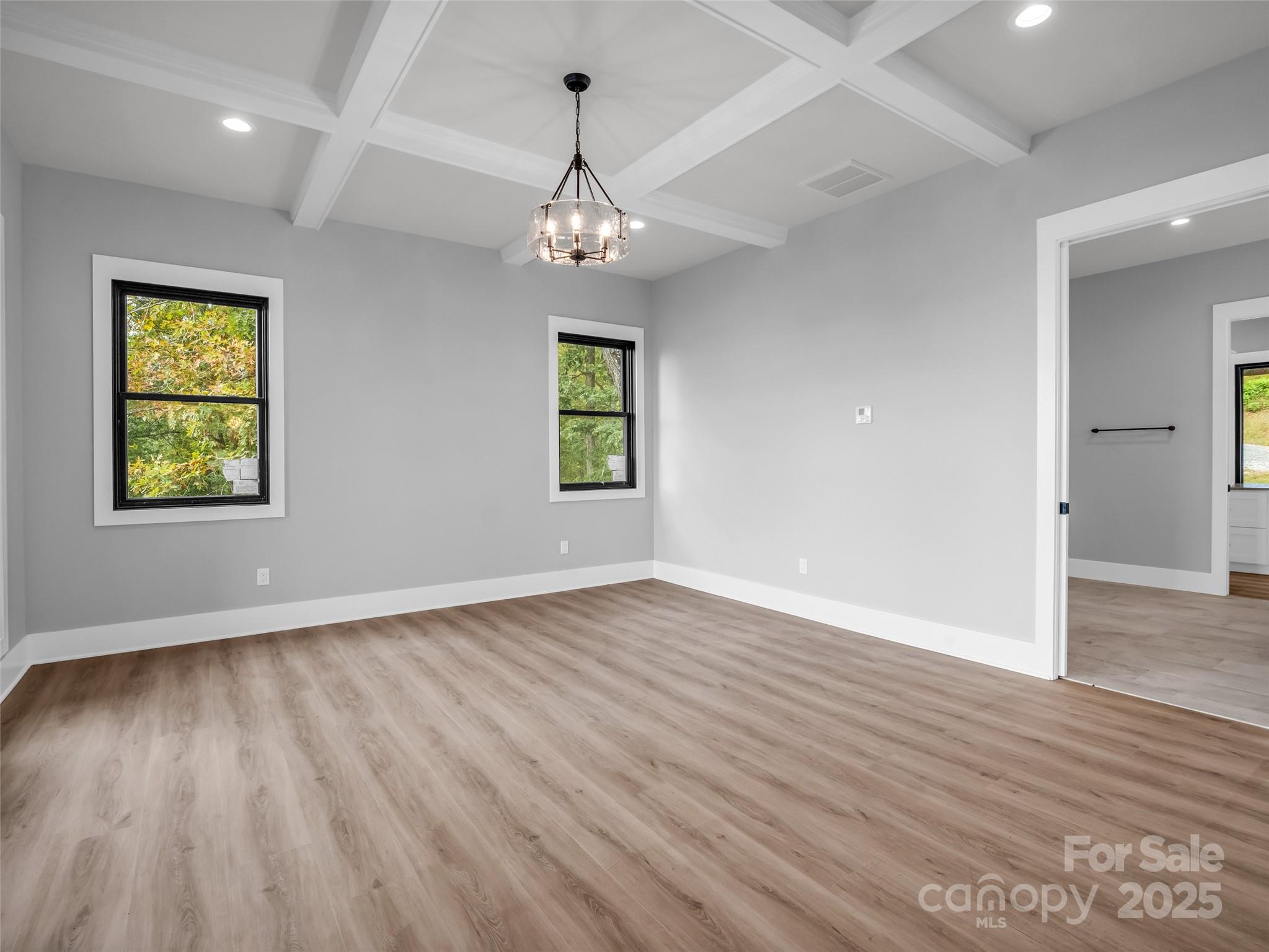 93 Chesterfield Drive Mill Spring, NC 28756 - Photo 15 of 48 an empty room with wooden floor chandelier and windows