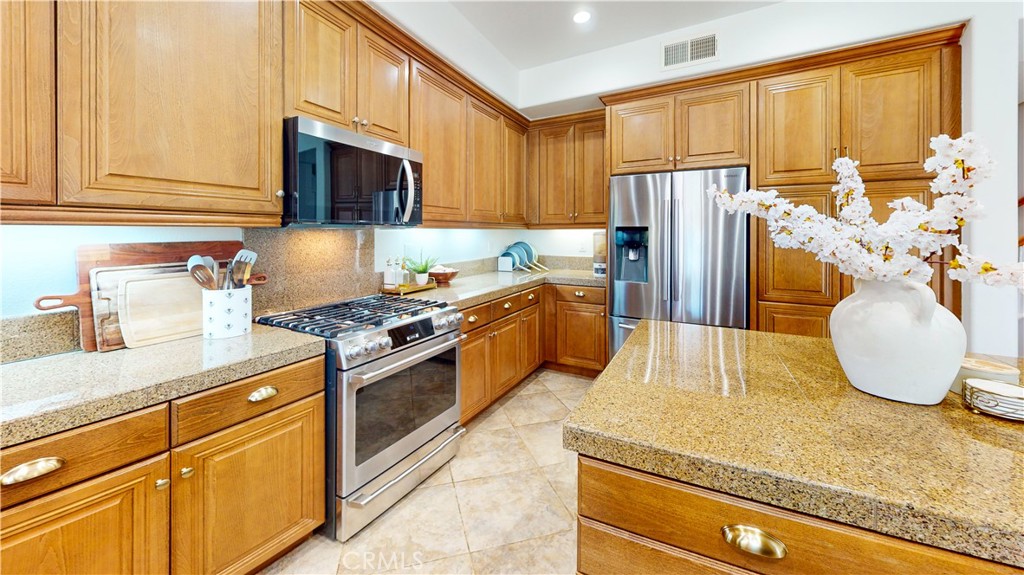 1279 Longbranch Road San Jacinto, CA 92582 - Photo 6 of 35 a kitchen with stainless steel appliances granite countertop a sink a stove and refrigerator