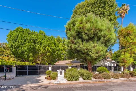 a view of a yard with plants and brick wall