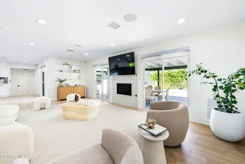 a living room with furniture a flat screen tv and a fireplace