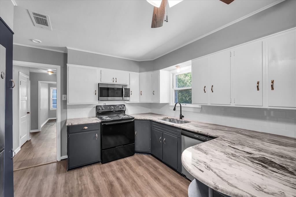 1325 Sunset Street Waco, TX 76710 - Photo 11 of 40 Kitchen featuring white cabinets, appliances with stainless steel finishes, light wood-style flooring, ceiling fan, and ornamental molding