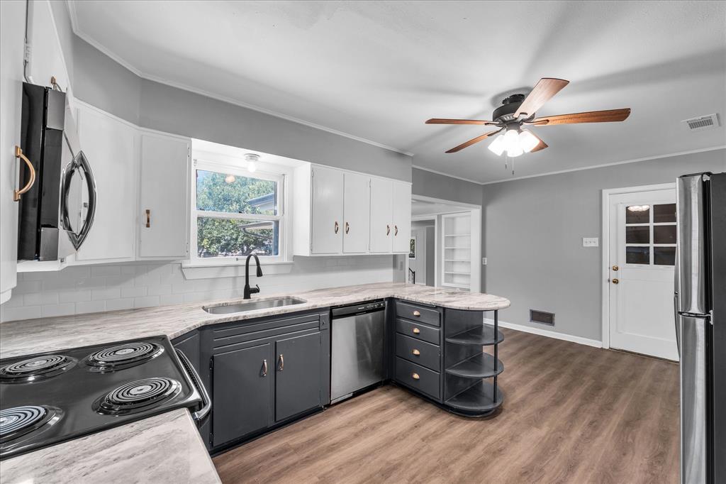 1325 Sunset Street Waco, TX 76710 - Photo 12 of 40 Kitchen with white cabinets, ornamental molding, light wood-type flooring, stainless steel appliances, and gray cabinetry