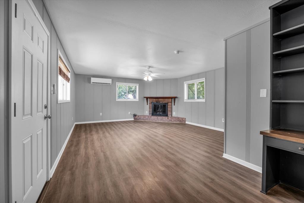 1325 Sunset Street Waco, TX 76710 - Photo 18 of 40 Unfurnished living room with dark wood-type flooring, a fireplace, and ceiling fan