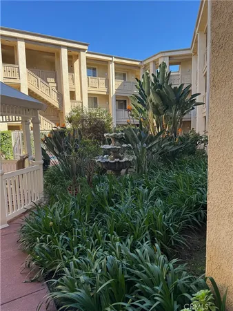 a view of a house with plants and wooden fence