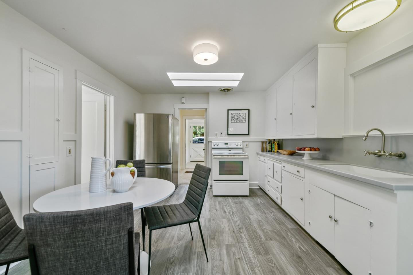 132 Alta Vista Road Woodside, CA 94062 - Photo 13 of 44 a kitchen with a table chairs sink and white cabinets