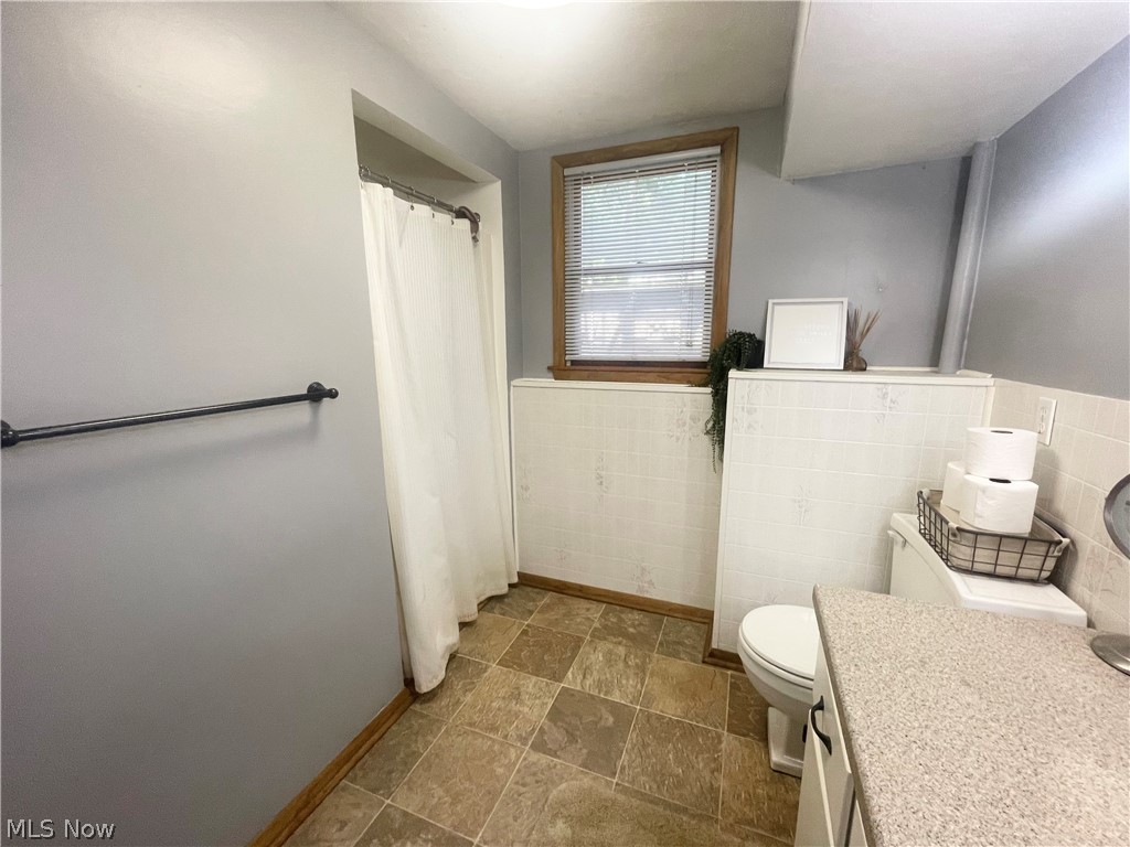 3047 Killian Road Uniontown, OH 44685 - Photo 21 of 36 Bathroom with tile flooring, tile walls, toilet, and vanity - lower level