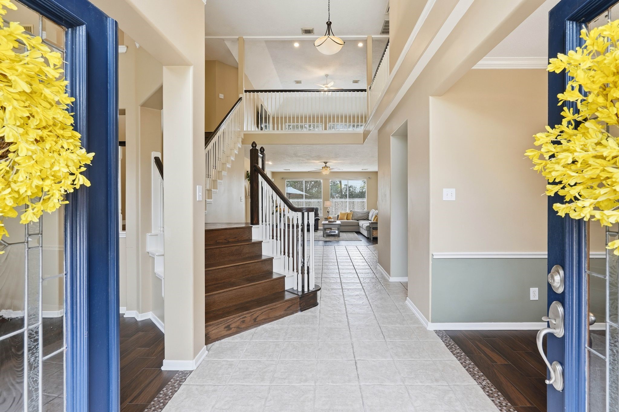 2515 Woodsboro Drive Spring, TX 77388 - Photo 2 of 44 This welcoming entryway features a bright, open foyer with high ceilings. The elegant hardwood staircase leads to the upper level, while the hallway opens into a spacious living area with large windows. The neutral tones and tile flooring create a warm, inviting atmosphere.