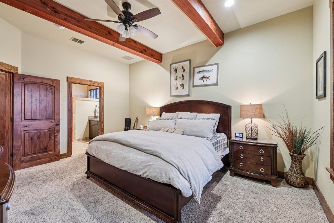 7229 Trident Jonestown, TX 78645 - Photo 12 of 34 a bedroom with a bed a lamp and a dresser