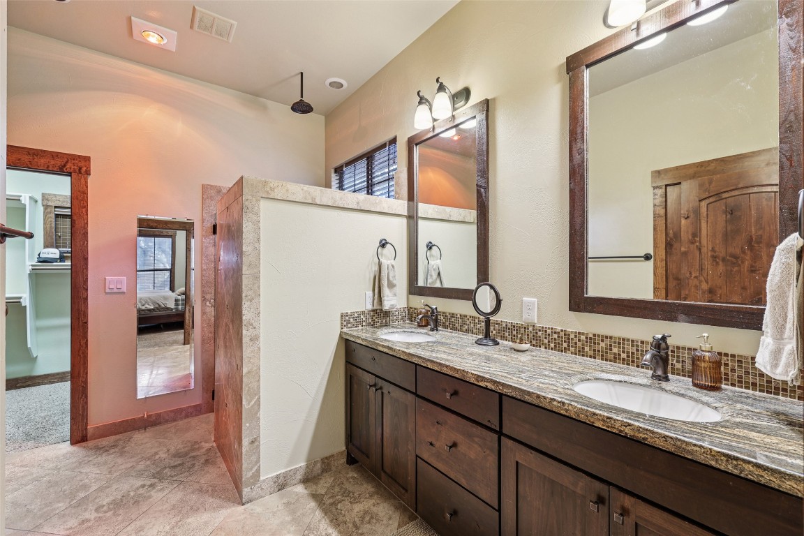 7229 Trident Jonestown, TX 78645 - Photo 13 of 34 a bathroom with a granite countertop sink double vanity and a mirror