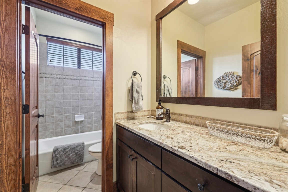 7229 Trident Jonestown, TX 78645 - Photo 21 of 34 a bathroom with a granite countertop sink and a mirror