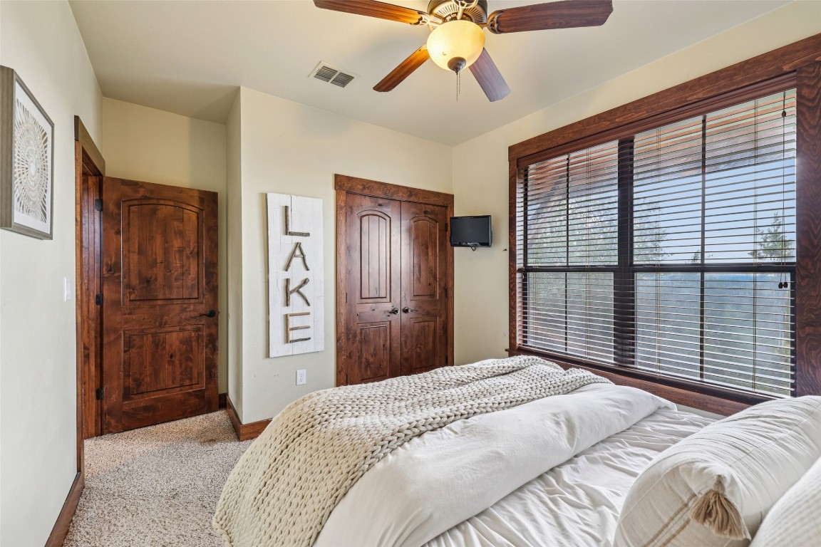 7229 Trident Jonestown, TX 78645 - Photo 23 of 34 a bedroom with a large bed and a chandelier
