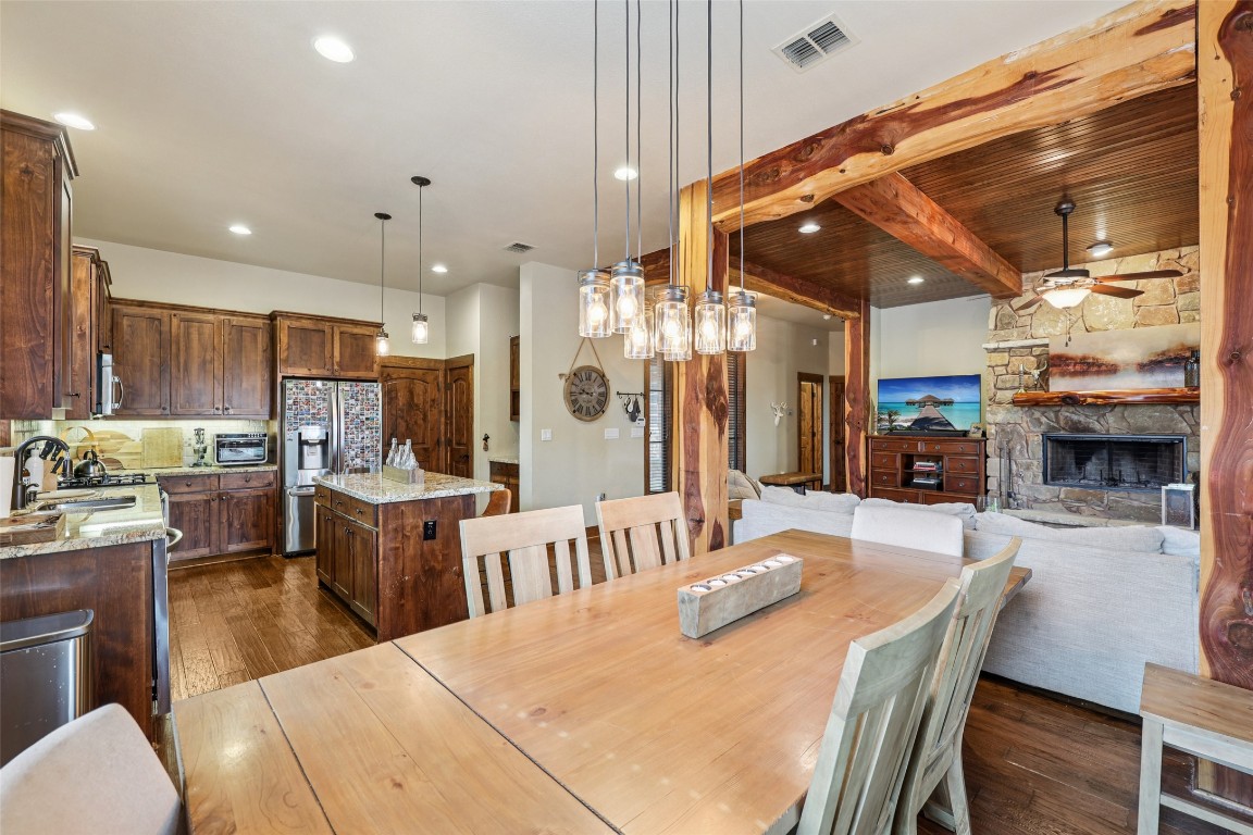 7229 Trident Jonestown, TX 78645 - Photo 7 of 34 a dining hall with stainless steel appliances kitchen island granite countertop a dining table and chairs