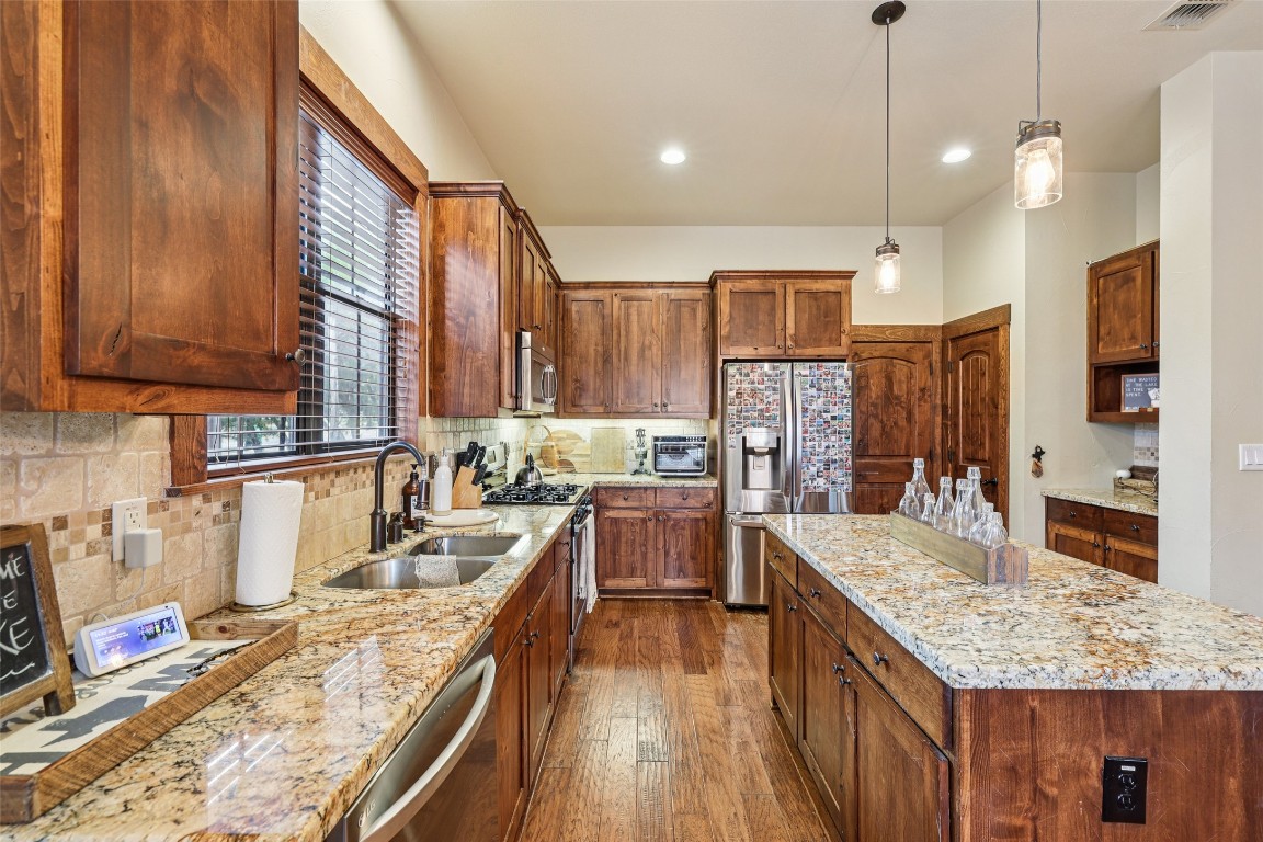 7229 Trident Jonestown, TX 78645 - Photo 8 of 34 a kitchen with granite countertop lots of counter top space appliances and a center island