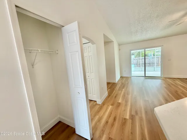 a view of a kitchen with kitchen island a sink wooden floor and living room view