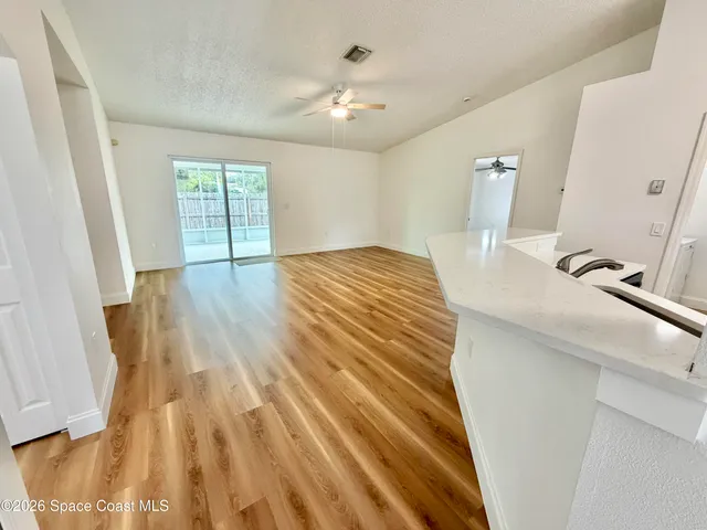 a hallway view with furniture a wooden floor and a sink