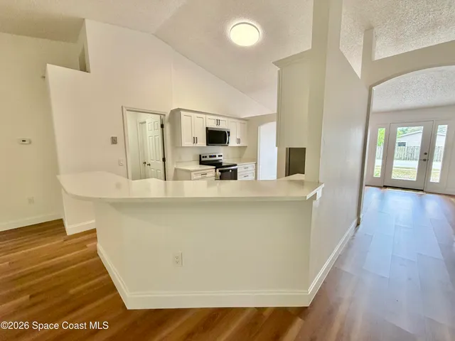 a kitchen with white cabinets and white appliances