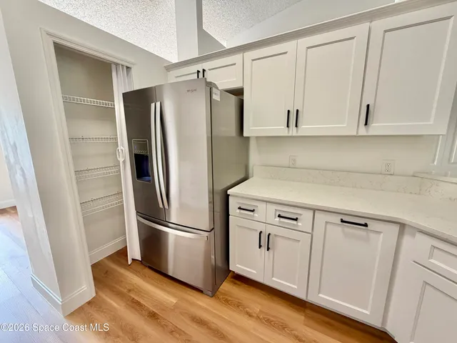 a view of a room with wooden floor and ceiling fan
