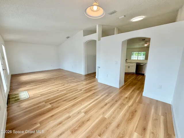 a view of empty room with wooden floor